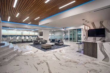 Modern office lounge with marble floors, wood ceilings, and glass walls at SC3 International HQ.