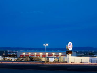Utility Trailer warehouse illuminated at night with bright signage and red service bays.