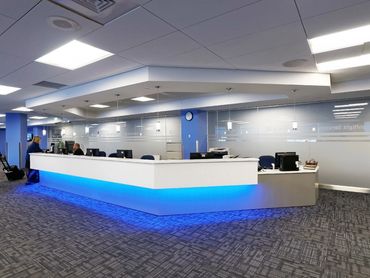 United Airlines service counter with modern lighting, glass partitions, and blue LED accent design.