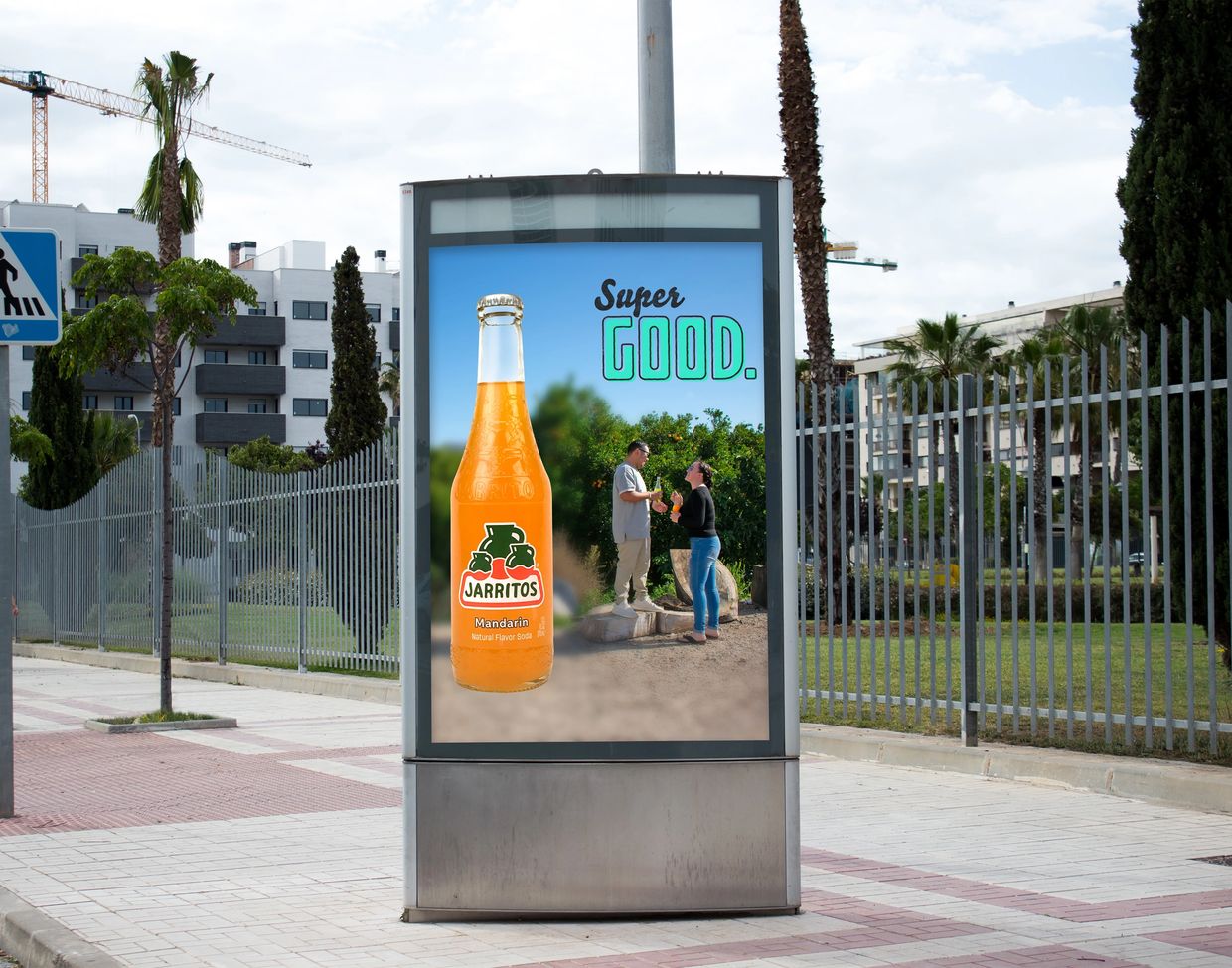 Outdoor ad for Jarritos Mandarin soda with two people enjoying the drink.