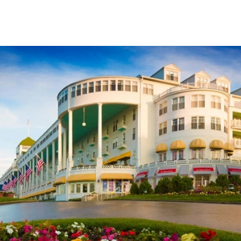 Historic luxury hotel with American flags and beautiful landscaping.