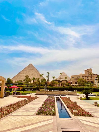 View of the Great Pyramids of Giza from a beautifully landscaped garden.