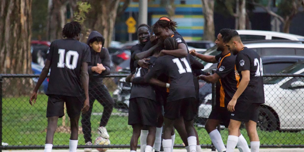 Soccer players celebrating a goal on the field.