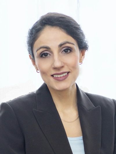 Femme souriante vêtue d'une veste noire.