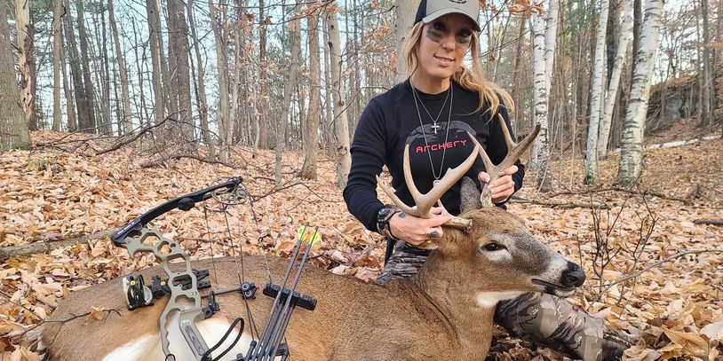 Amanda Lynn Mayhew with an APA archery bow and a deer while deer hunting.