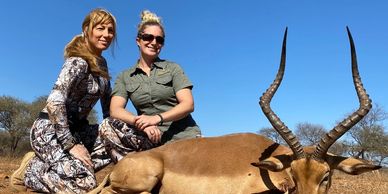 Two girls and an impala in Africa.