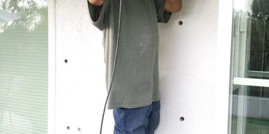 Person using a metal detector outside a building.