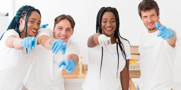 Group of volunteers smiling and pointing.
