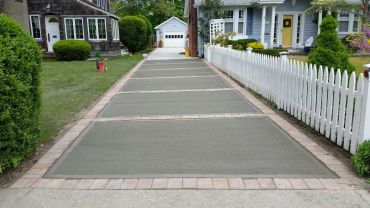 Newly poured concrete driveway between two houses.