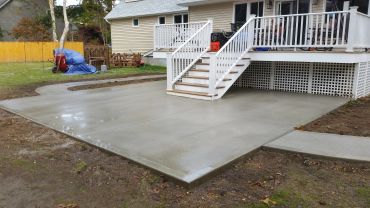 Newly poured concrete patio outside a house.
