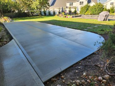 Newly poured concrete driveway in a backyard.