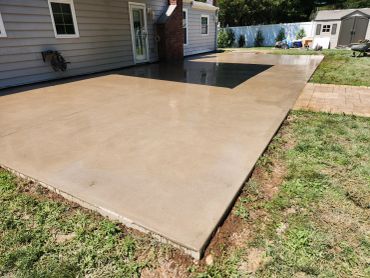 Newly poured concrete patio outside a house.