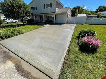 Newly paved driveway in front of a suburban house.