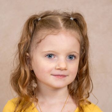 Close-up of a little girl with blue eyes and pigtails.