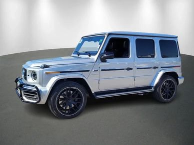 Silver Mercedes-Benz G-Class SUV parked indoors with black wheels.