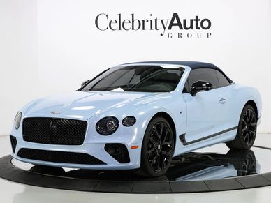 Light blue Bentley convertible with black soft top and wheels.