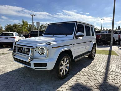 White Mercedes-Benz G-Class SUV parked outdoors under a clear sky.