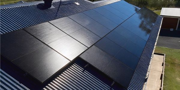 Solar panels installed on a metal roof under sunlight.