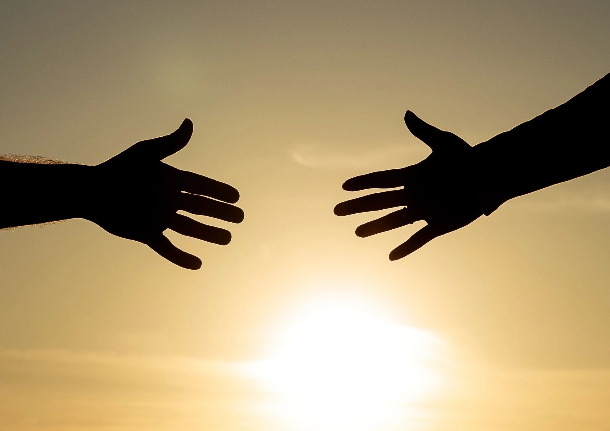 Hands reaching for each other for help and support. Life coach Los Angeles