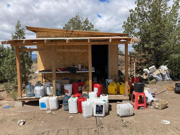 Several chemicals outside a wooden shed