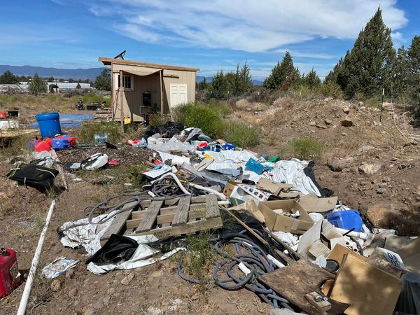 Trash piled up outside a wooden shed