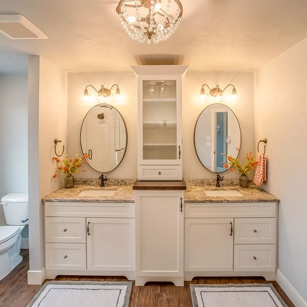 A bright and elegant bathroom features a dual-sink vanity with white cabinets