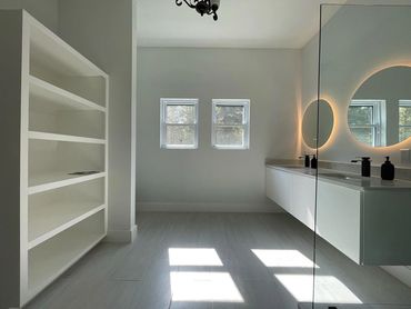 White bathroom 
Floating vanity 
White cabinet 
Grey tile
