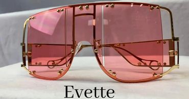 Trendy oversized sunglasses with pink lenses and gold studs.