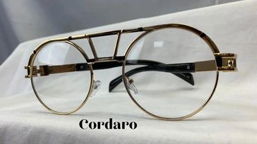 Elegant gold-framed eyeglasses with clear lenses on white fabric.