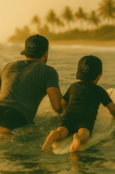 Father and son in matching hats learning to surf together at sunset.