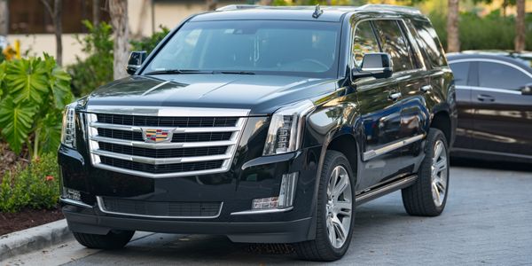 Black Cadillac Escalade parked on a residential street.