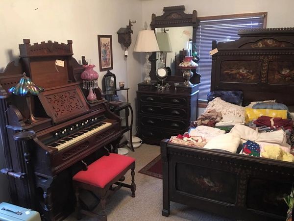 Antique furniture including an ornate organ and matching antique dresser and headboard. 