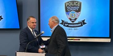 Two men shaking hands at St. Charles County Police event.