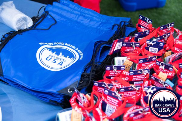 Blue event bags and red VIP lanyards for Bar Crawl USA festival.