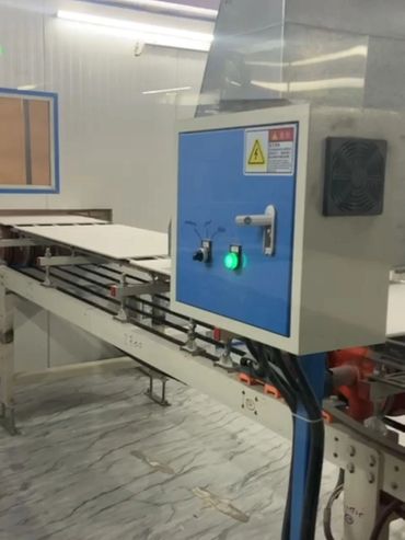 Industrial machine with control panel operating in a factory.