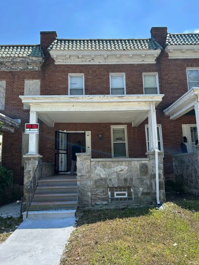 Brick townhouse with a small front porch and 'For Rent' sign.