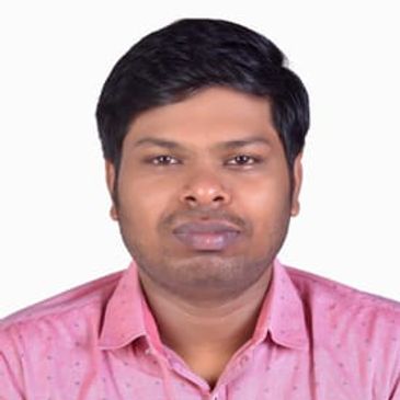 Dr. Vignesh Subramaniyan, surgeon, in pink shirt, smiling.