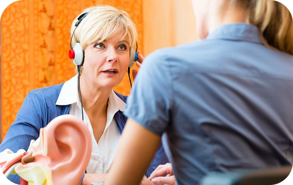 Woman with headphones participates in focused audiogram speech therapy session.