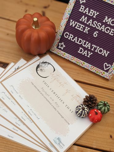 Certificates for completing baby massage course with autumn-themed decorations.
