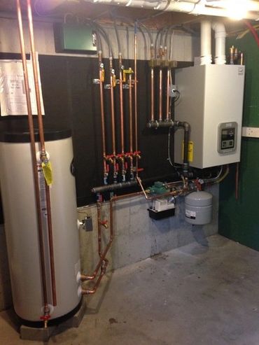A neatly installed home heating system with copper pipes and a water heater.