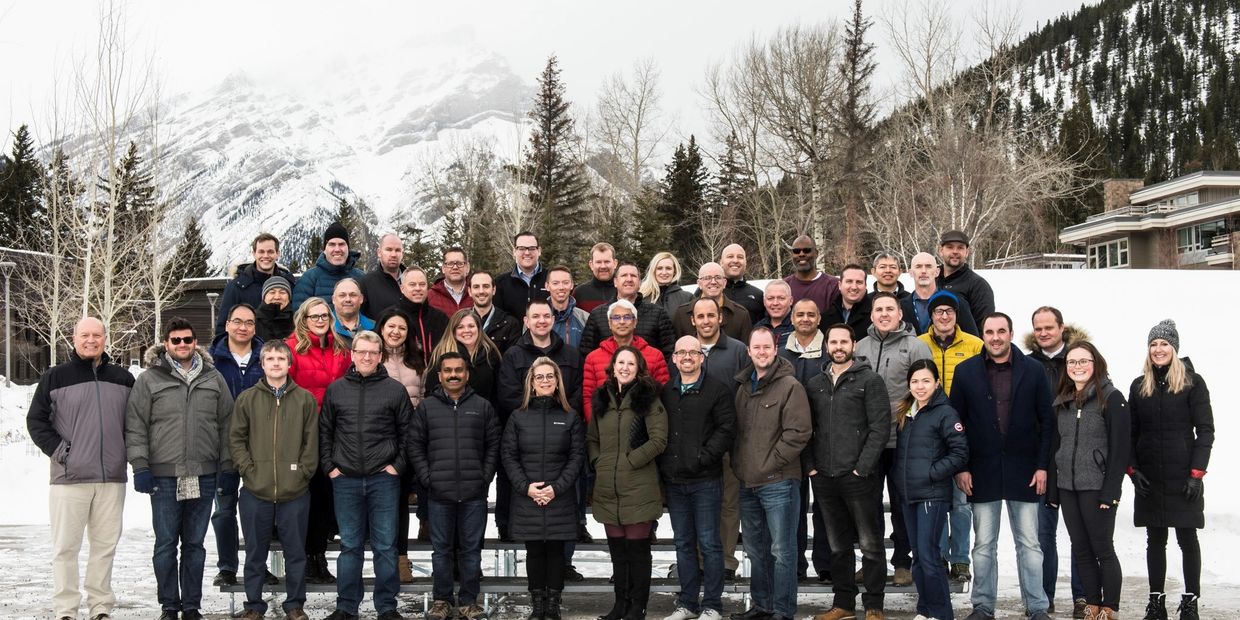 Large group photo in snowy mountain setting.