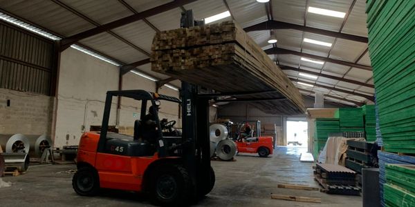 Forklift operator moving timber product.