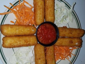 Mozzarella sticks arranged around a cup of marinara sauce with shredded carrots and cabbage.