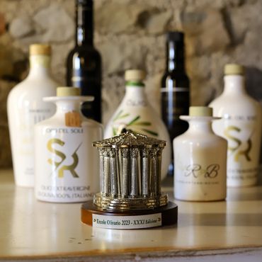 A miniature trophy with bottles in the background on a shelf.