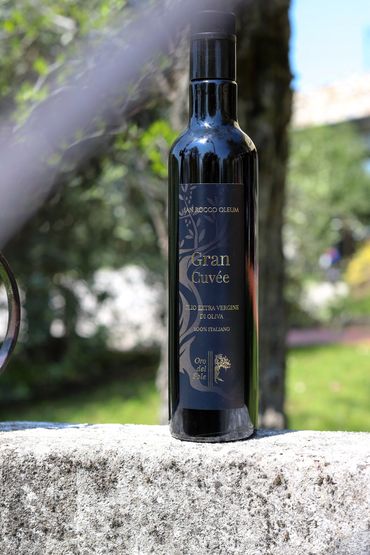 A bottle of Gran Cuvée extra virgin olive oil outdoors.