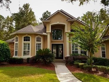 Exterior house with beige walls and white accent trim, 2 story, pillars white, luxury landscaping,
