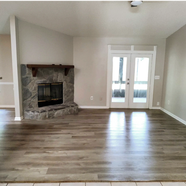 grey walls, white trim, french doors leading to the backyards. Fireplace, freshly painted walls