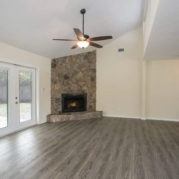 Beige colr walls wiht LVP floorig, brick fire place, new ceiling fan installed with light kit
