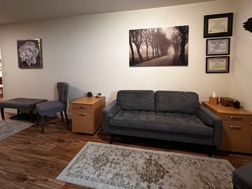 Cozy living room with gray furniture and wall art.