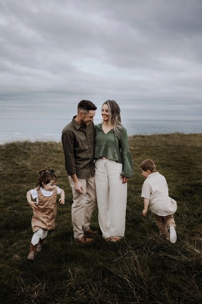 Mum and dad with kids running around them during an outdoor family photography session. Darwin NT
